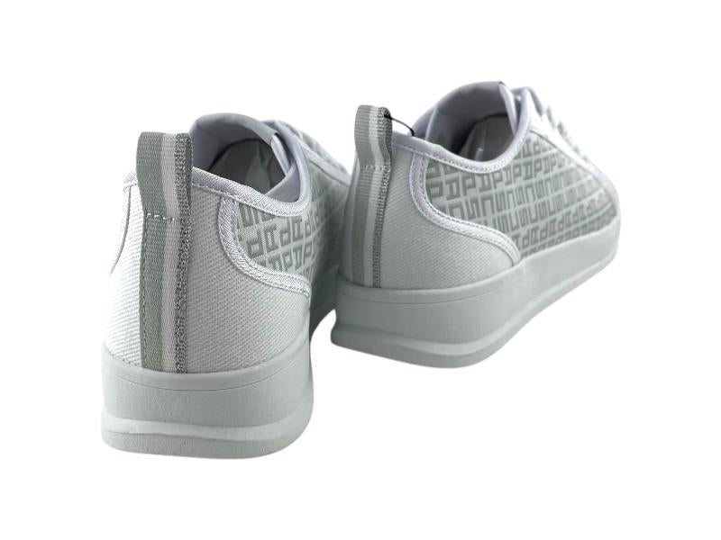 Vista por la parte de atrás de unos tenis de mujer en loneta blanca y detalles monograma en gris plata sobre fondo blanco.