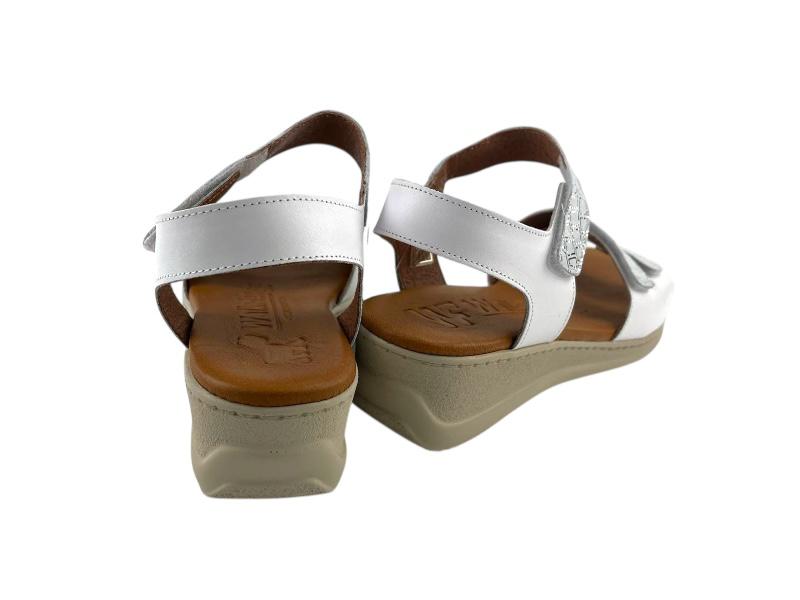 Sandalias en piel muy cómodas. en color blanco y cierre de velcro en color plata, plantilla en gel ergonómica y ligera, cuñas medias con suela en color gris.