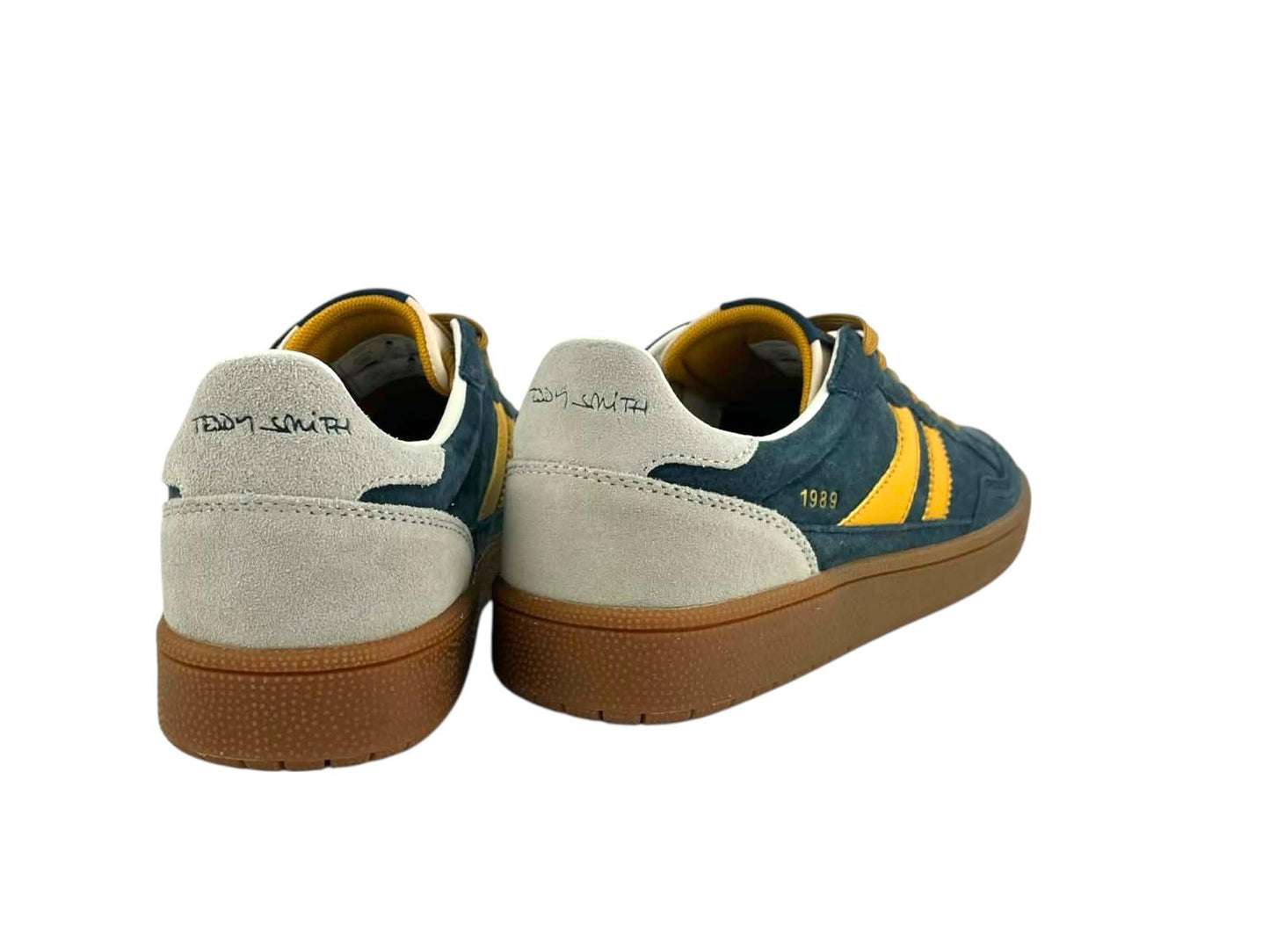 Vista por la parte de atrás de unos sneakers retro running 1989, con detalles de la marca en el talón y cuidada silueta en color caramelo.