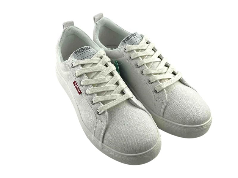 Zapatillas de lona, en color blanco puro, de hombre o mujer, de estilo casual y diseño clásico, con cordones, de la marca de la marca española Yumas sobre fondo blanco.