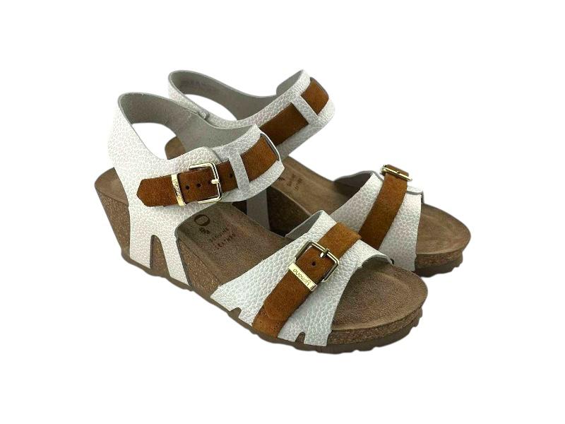 Vista lateral derecha de unas sandalias de piel, de mujer, blancas, ergonómicas y con cuña. Cierre regulable por hebillas en tiras de piel color avellana en empeine y tobillo; sobre fondo blanco.