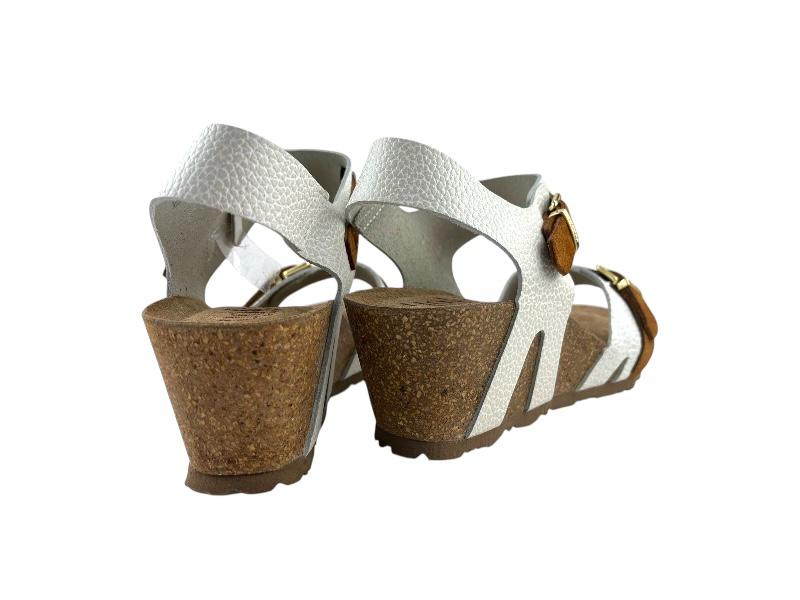 Vista lateral de unas sandalias de mujer ergonómicas, con cuña de corcho y piel blanca sobe fondo blanco.