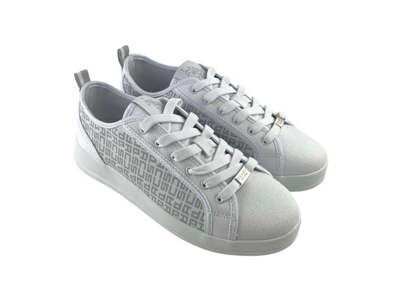 Vista lateral izquierda de unos tenis de diseñador, blancos, de mujer, con patrón monograma tipo lujo lateral y cierre de cordones, sobre fondo blanco. 