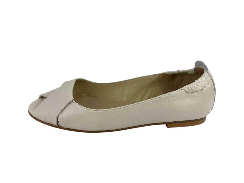 Vista lateral derecha  de un zapato en piel, estilo peep toe con nudo en el empeine sobre fondo blanco.