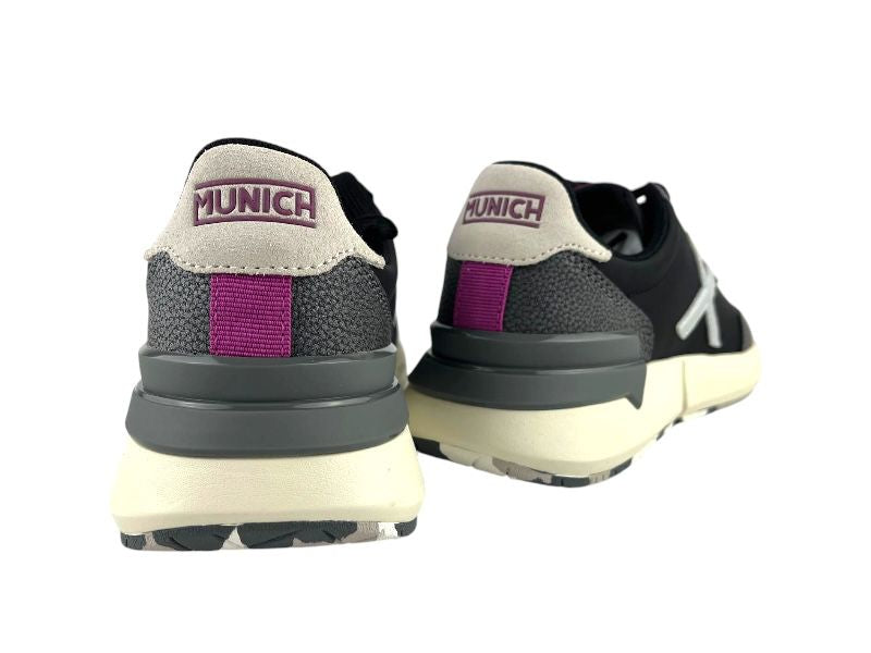 Sneakers de mujer vista por la parte de atrás en color gris, con logo de la marca Múnich en fucsia, fondo blanco.