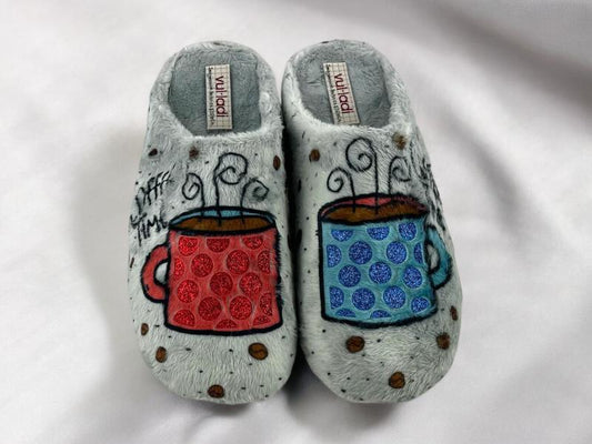 Vista frontal de unas zapatillas descalzas de mujer con estampado de tazas de café roja y azul,  y eslogan Coffe time sobre paño grueso.