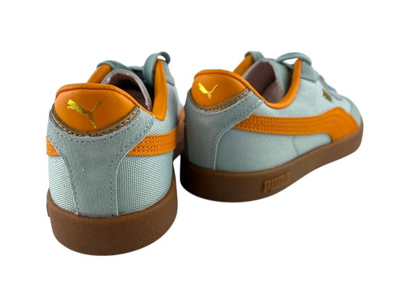 Vista por la parte de atrás de unas zapatillas para mujer Puma clásicas, color azul menta con franja naranja vibrante, detalles dorados y suela de goma marrón. 