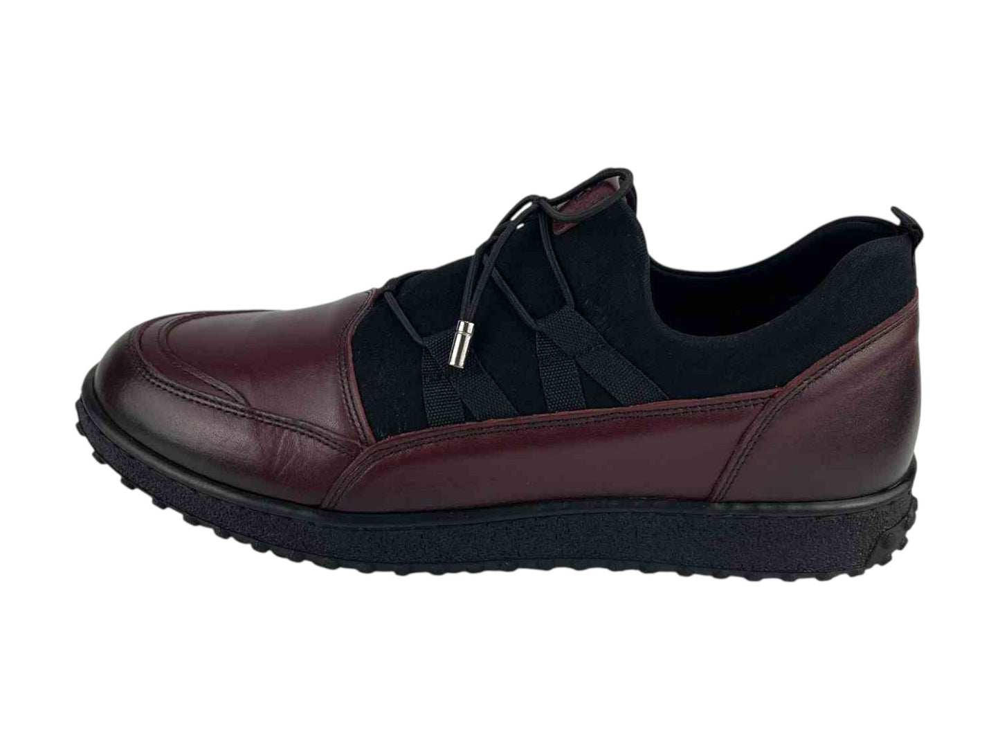Vista lateral de un zapato, en piel legítima,   muy cómodo de mujer, en color burdeos y elástico en empeine color negro. Suela de goma antideslizante.
