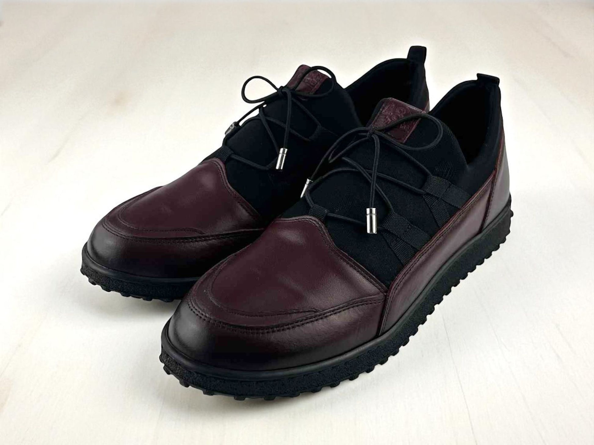 Zapatos cómodos de mujer, en piel legítima, color burdeos, con elásticos en el empeine y cordones decorativos.