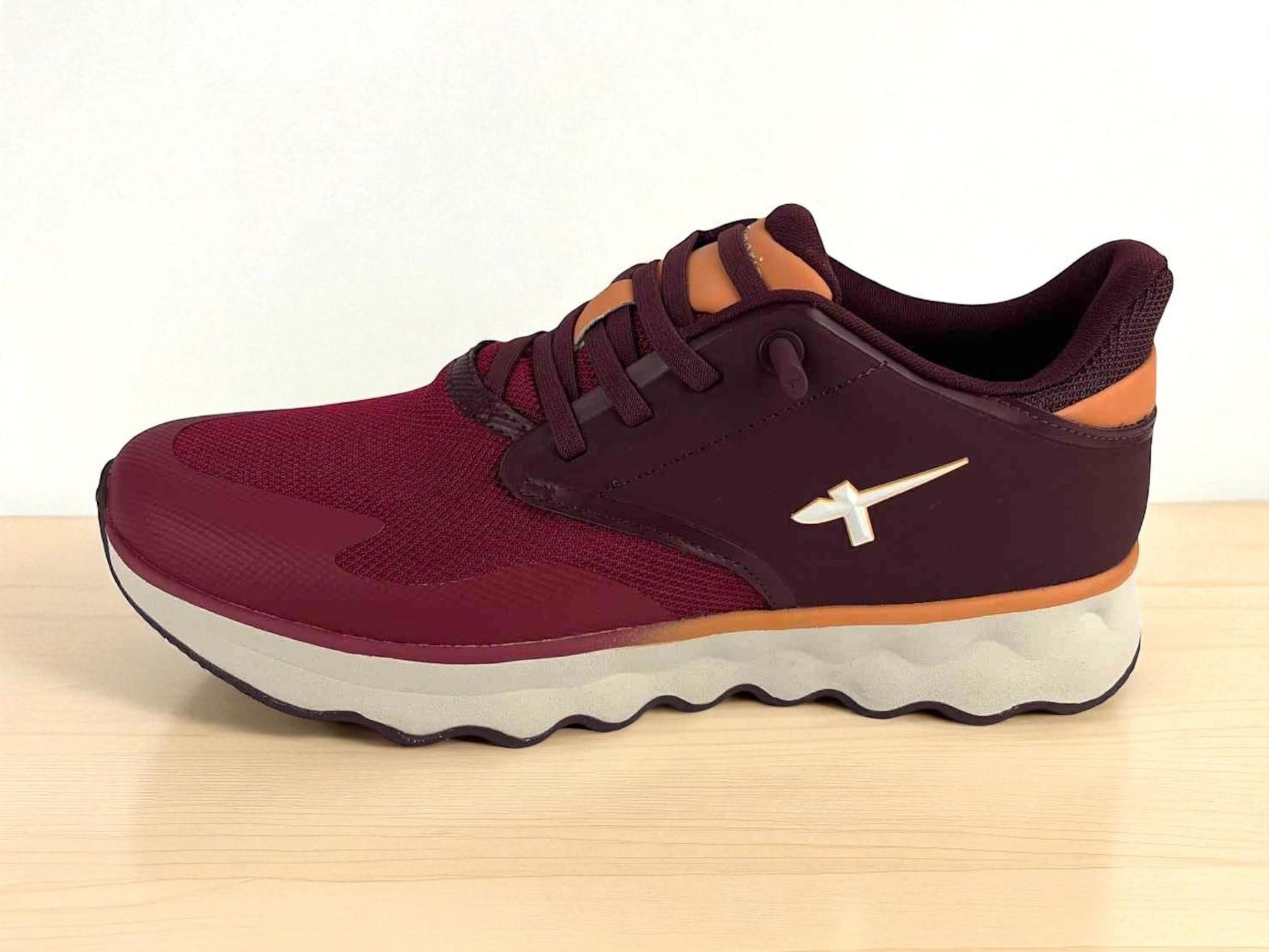 Tenis de mujer muy ligeros, en malla elástica en color burdeos y detalles en naranja, con logo de la marca Tamaris en el lateral, tenis de estilo casual.