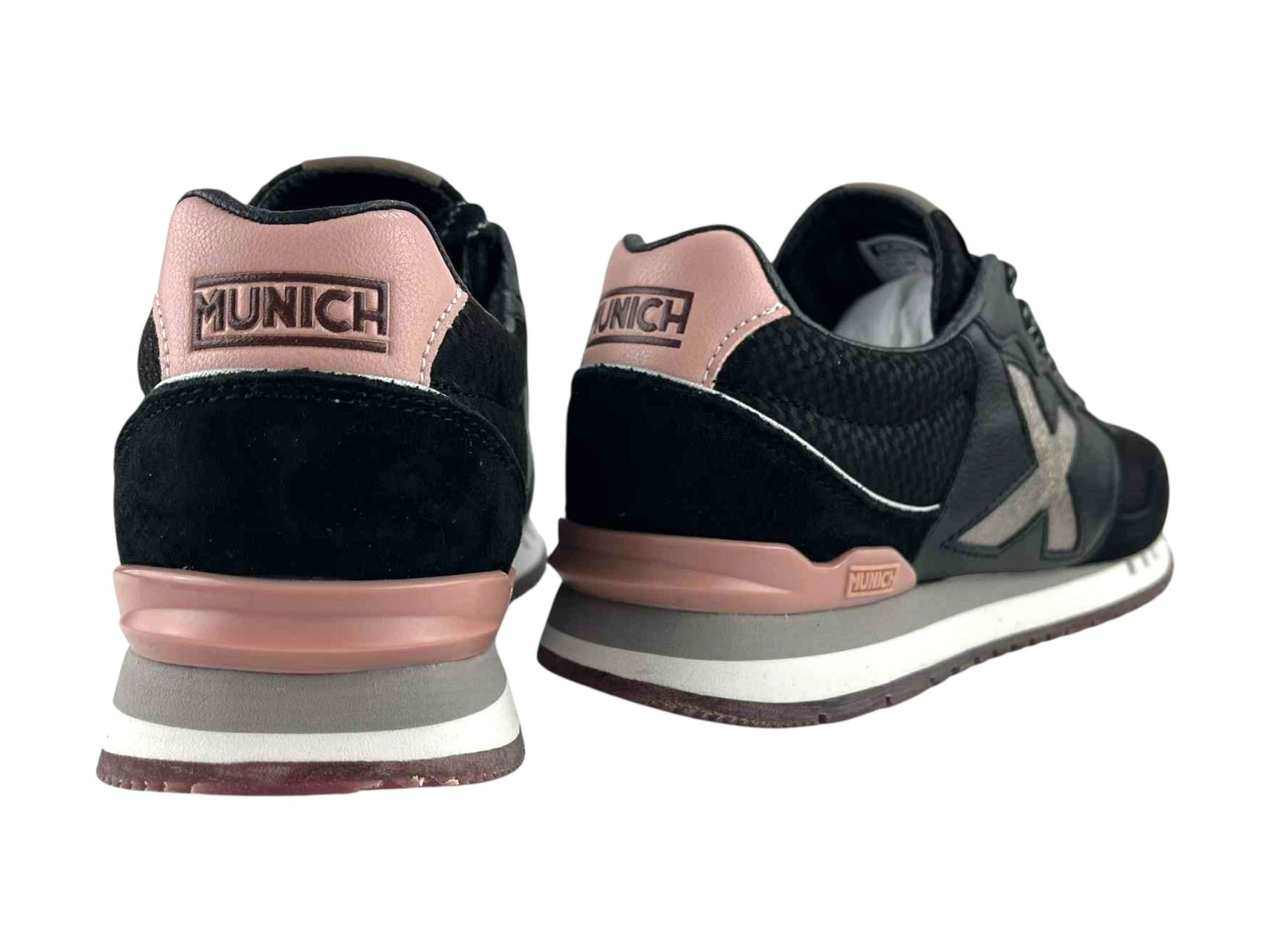 Vista por la parte de atrás de unos sneakers de calle, de mujer, de la marca Munich, con detalles en rosa y logo de la marca en el talón en color negro.