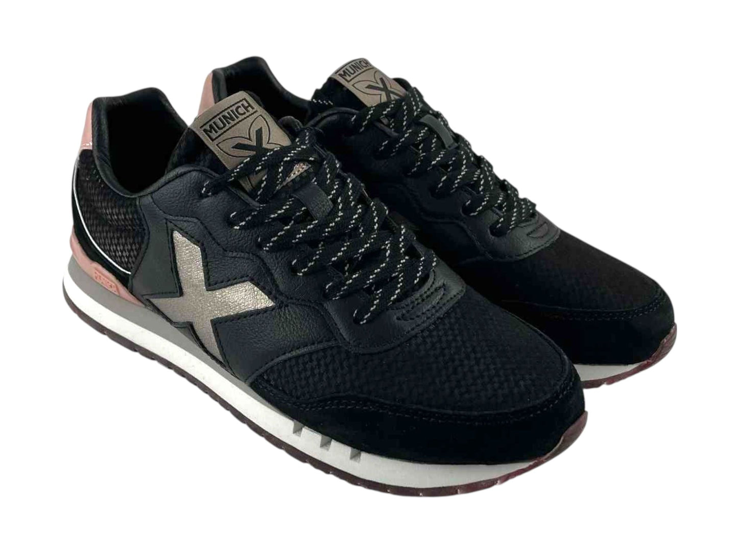 Diseño atractivo y moderno de unas zapatillas de mujer, en color negro en diferentes texturas, piel y textil y detalles en color rosa en el talón. Logo en X metalizado en el lateral, lengüeta y talón logo Munich de la marca. 