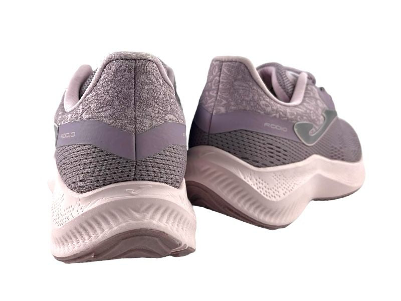 Sneakers de mujer con cordones, color lila, con logo de la marca en el lateral. Suela blanca. Fondo blanco. Vista por la parte de atrás  de los sneakers.