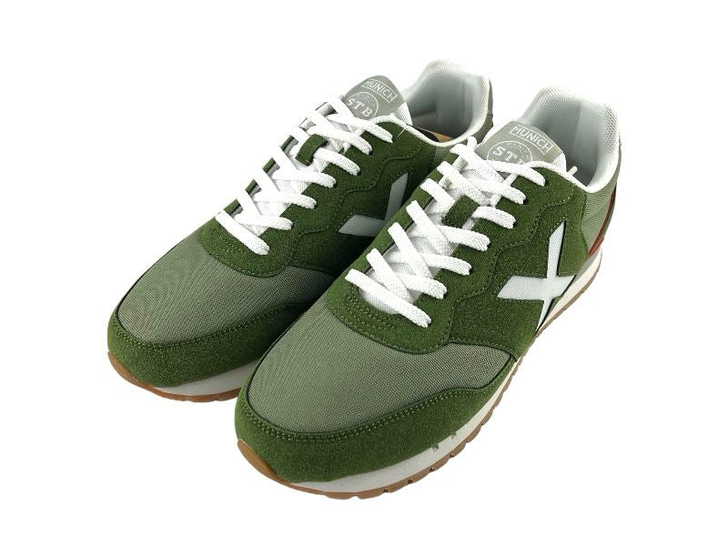Sneakers deportivos de hombre, con diferentes tonos de verde, logo en blanco de la marca en el lateral y en la lengüeta, con cordones. Vista lateral izquierda de los sneakers sobre fondo blanco.