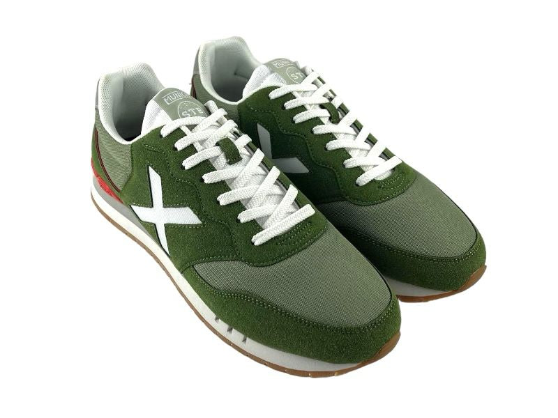Sneakers deportivos de hombre, con diferentes tonos de verde, logo en blanco de la marca en el lateral  y en la lengüeta, con cordones. Vista lateral derecha del sneaker sobre fondo blanco.