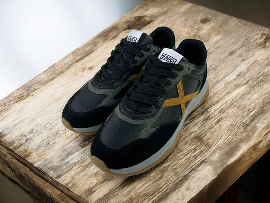 Zapatillas urbanas de la marca Munich estilo retro running en color negro, en piel legítima, con icónico logo en color ocre, con cordones y suela en color gris.