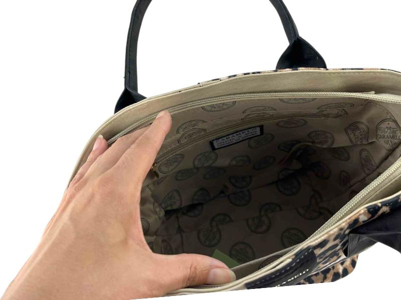 Interior de un bolso de la marca Caramelo en color beige y animal print leopardo, con cierre de cremallera, interior con bolsillo interno y logo de la marca.