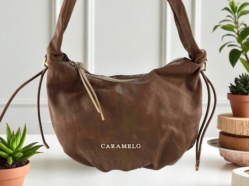 Bolso elegante de mujer de la marca Caramelo, estilo boho chic, realizado en piel sintética color marrón con asas regulables, muy ligero  en un solo departamento.