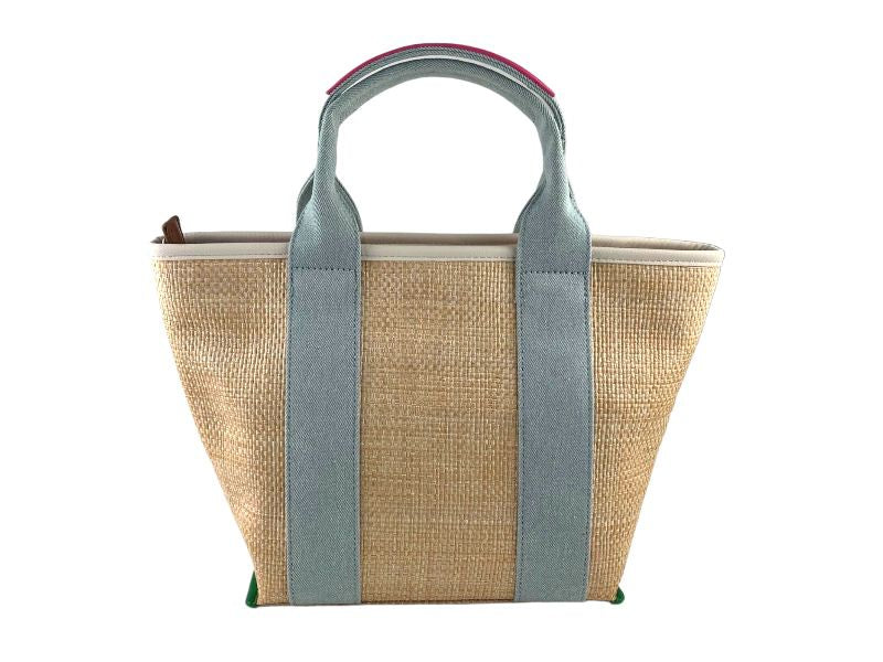 Bolso vegano de mujer en rafia, con detalles en vaquero en asas. Pompón en cuero vegano extraíble. Vista por la parte de atrás sobre fondo blanco.