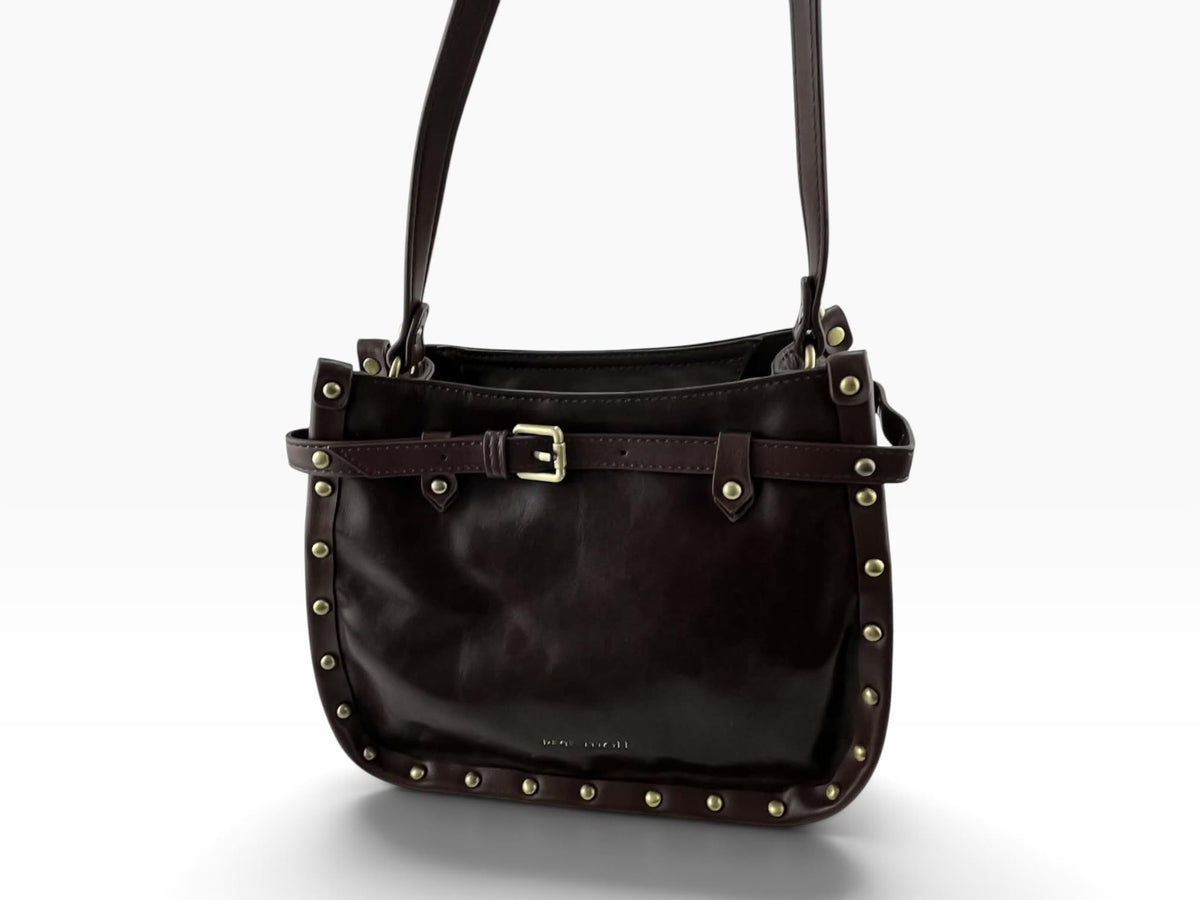 Vista frontal del bolso bandolera Pepe Moll de piel vegana marrón oscuro con tachuelas doradas, hebilla y correa de hombro.