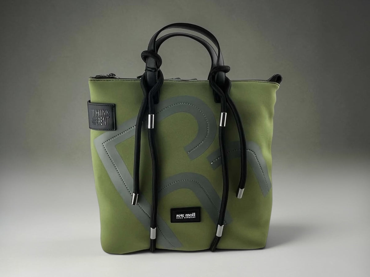 Mochila Pepe Moll verde oliva para mujer con asas negras, diseño gráfico frontal y detalles metálicos plateados.