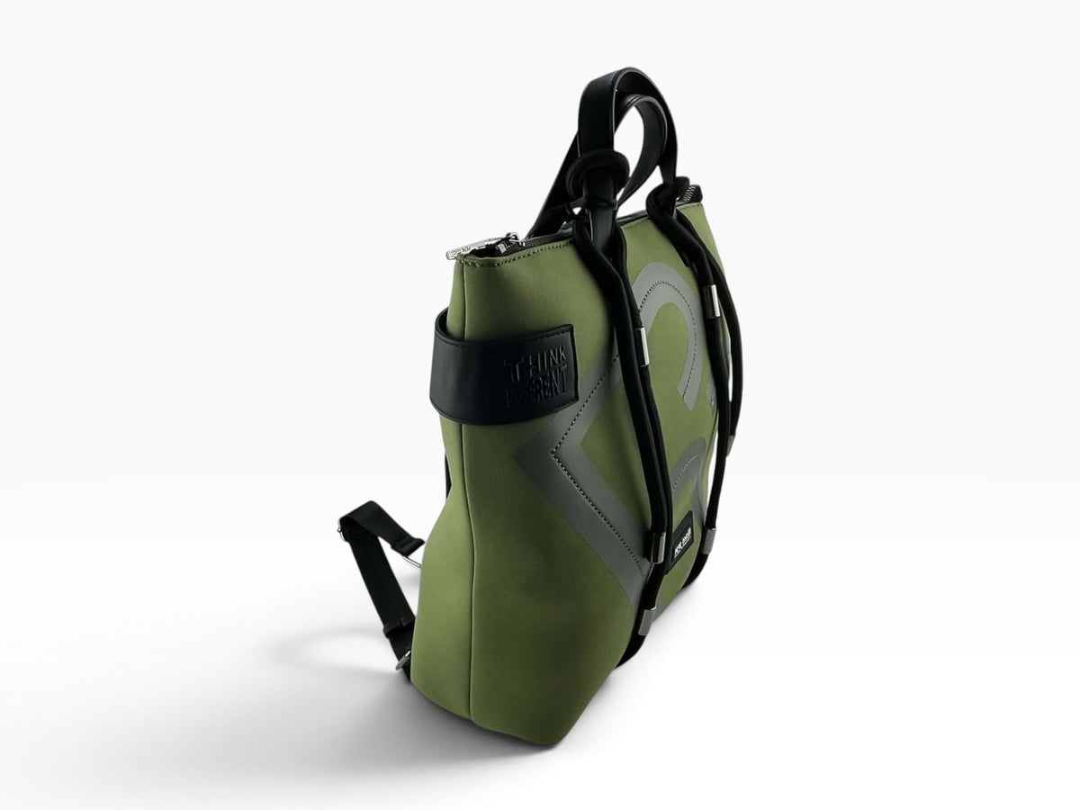 Vista lateral de mochila Pepe Moll verde oliva con asas negras, cierre superior de cremallera y detalle Think Different.