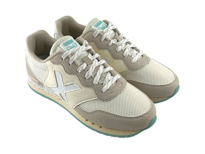 Vista lateral derecha de unos tenis de mujer, estilo retro running, de la marca Munich en color beige claro, con malla transpirable, cordones y suela de goma sobre fondo de blanco.