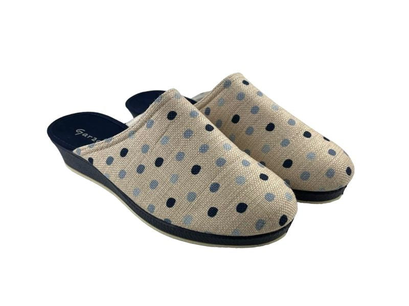 Zapatillas de mujer descalzas con topos sobre fondo beige, cuña en color marino. Vista lateral derecha de las zapatillas sobre fondo blanco.