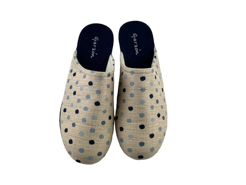 Zapatillas de mujer descalzas con topos sobre fondo beige, cuña en color marino.Vista frontal de las zapatillas sobre fondo blanco.