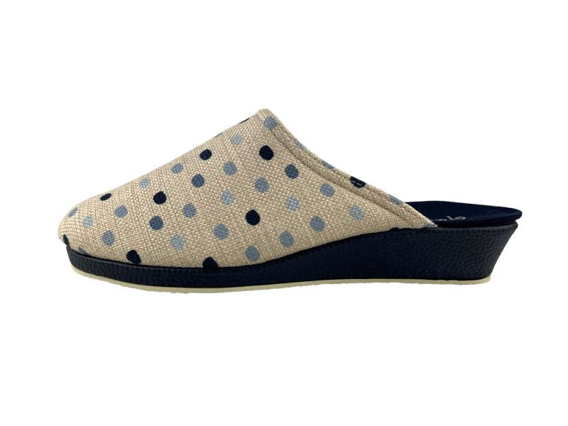 Zapatilla de mujer descalzas con topos azules sobre fondo beige, cuña en color azul marino. Vista lateral izquierda de sobre fondo blanco.