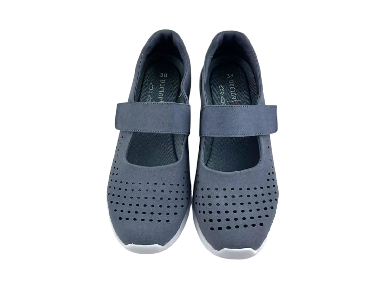 Primer plano de unos tenis de mujer calados láser sobre el corte gris azulado resaltando la ventilación y el acabado mate del zapato confort.