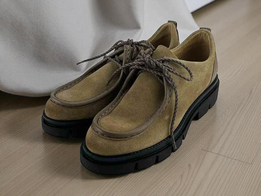 Zapatos de mujer en piel legítima de alta calidad, de la marca Lince, estilo wallabee, con cordones, suela track negra, muy ligeros y cómodos sobre suelo de madera clara.