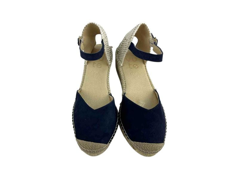 Vista frontal de unas alpargatas artesanales de yute, en piel ante azul marino, con escote en V. Puntera y talonera trenzada artesanal en color natural y pulsera de hebilla dorada al tobillo.