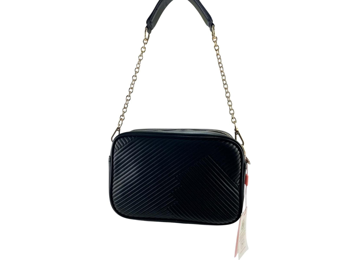 Bolso bandolera Noco negra de piel vegana con relieve plisado, cadena metálica dorada y logotipo NC tono sobre tono, vista frontal.