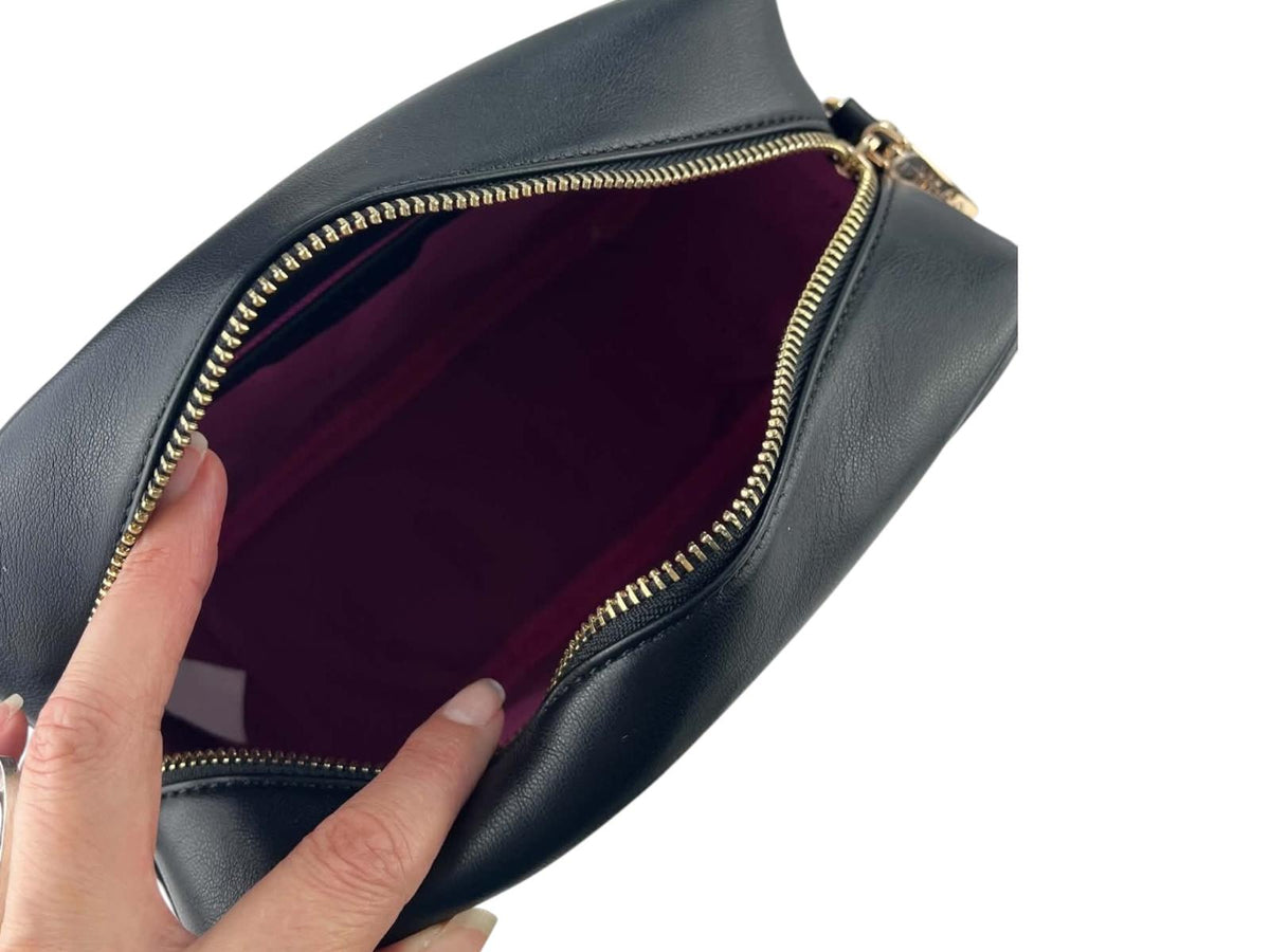 Interior de bandolera Noco negra con forro textil fucsia, cierre de cremallera y compartimento para móvil.