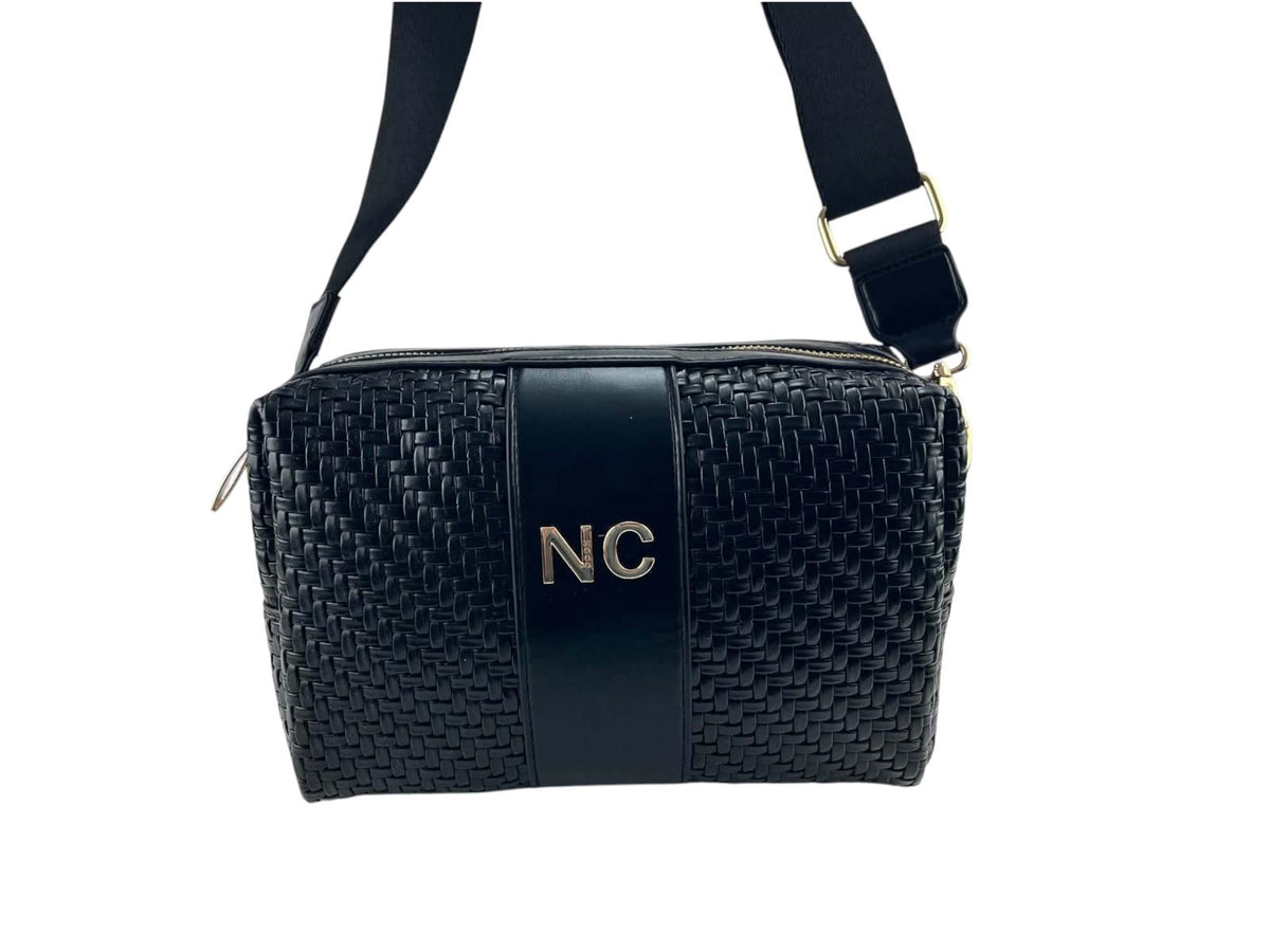 Bandolera Noco negra de piel vegana trenzada, detalle NC, correa regulable y herrajes dorados, vista frontal.