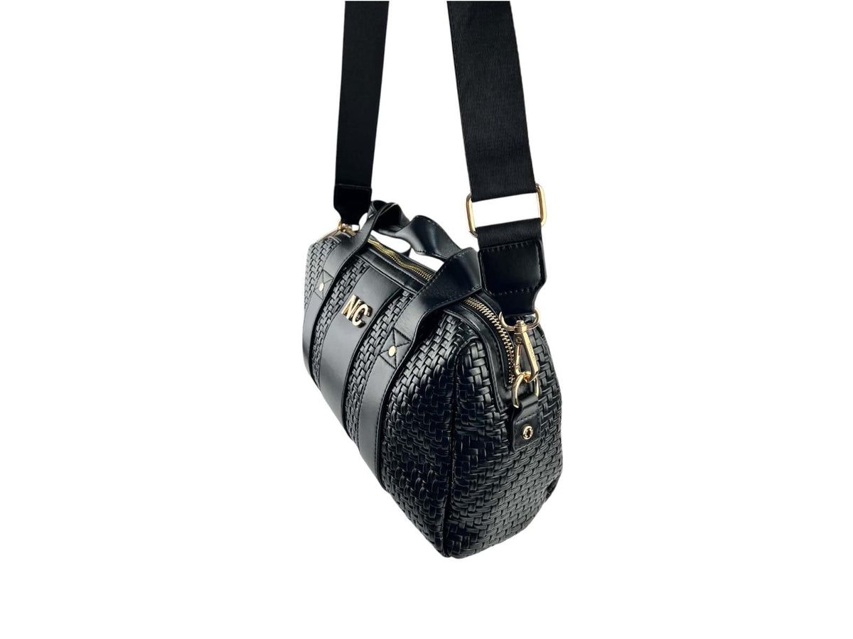 Vista lateral del bolso bowling Noco negro trenzado con correa extraíble regulable y herrajes metálicos dorados.
