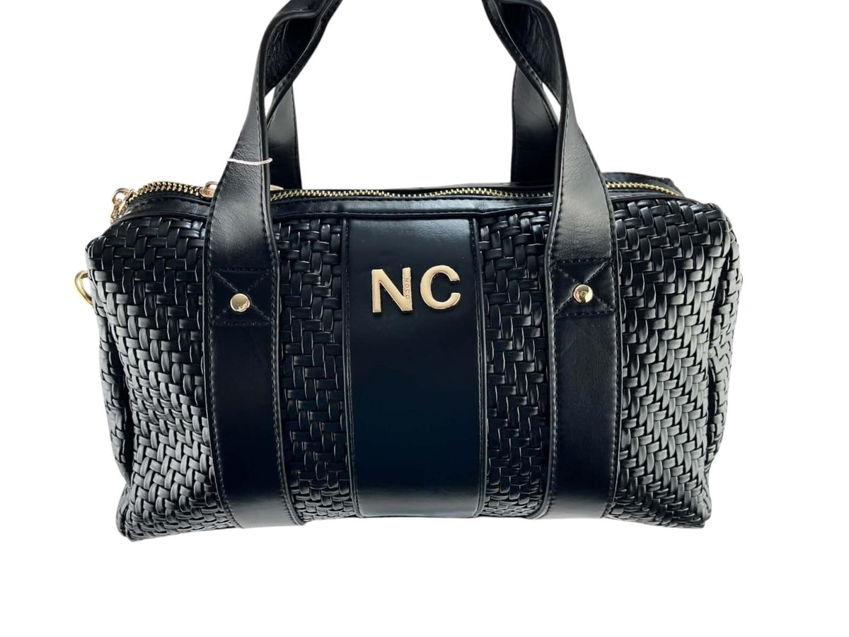 Vista frontal del bolso bowling Noco negro con tejido trenzado, dos asas y logotipo NC dorado.