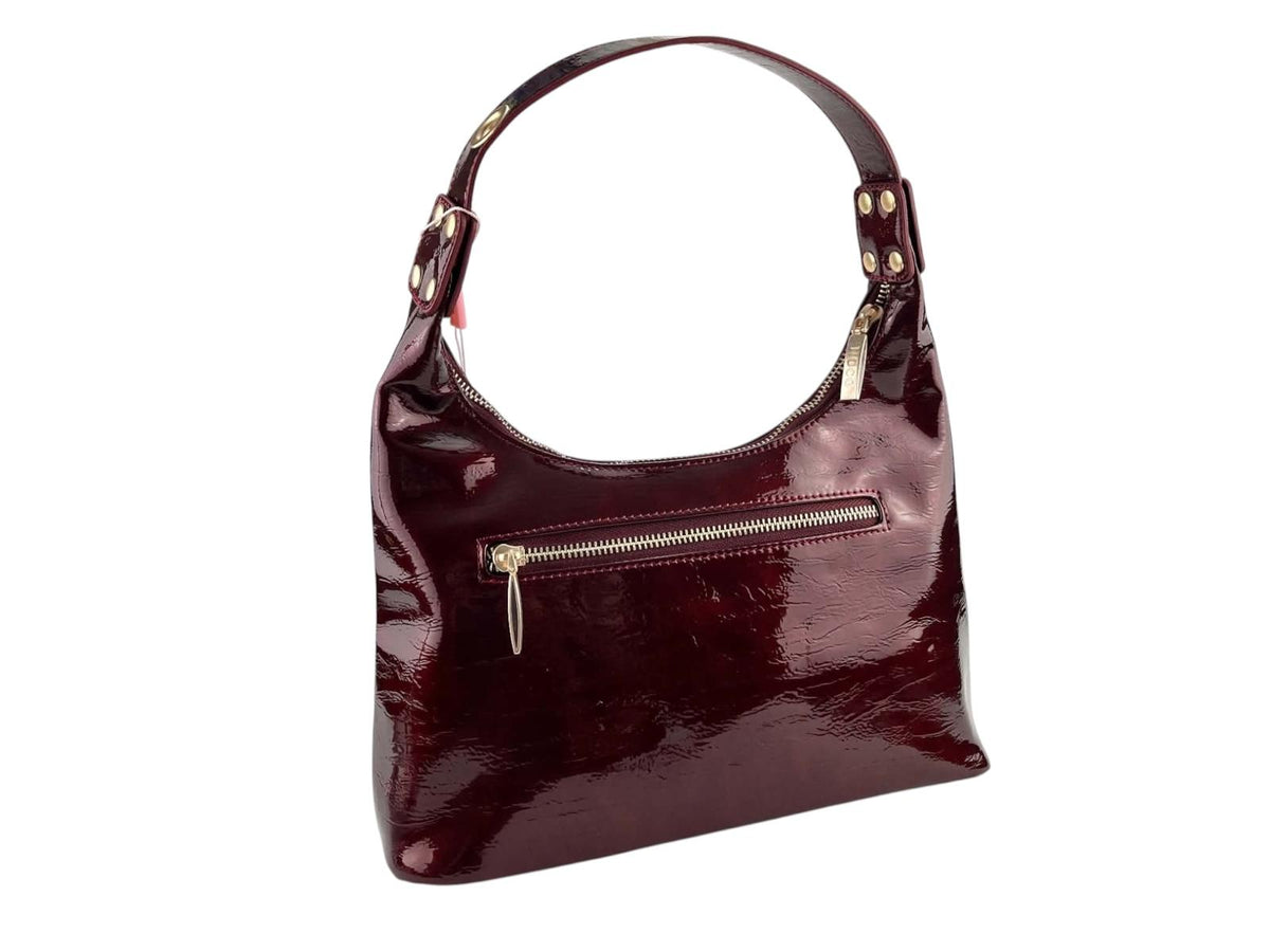 Vista trasera del bolso góndola Noco burdeos efecto charol, con bolsillo exterior de cremallera y asa de hombro.