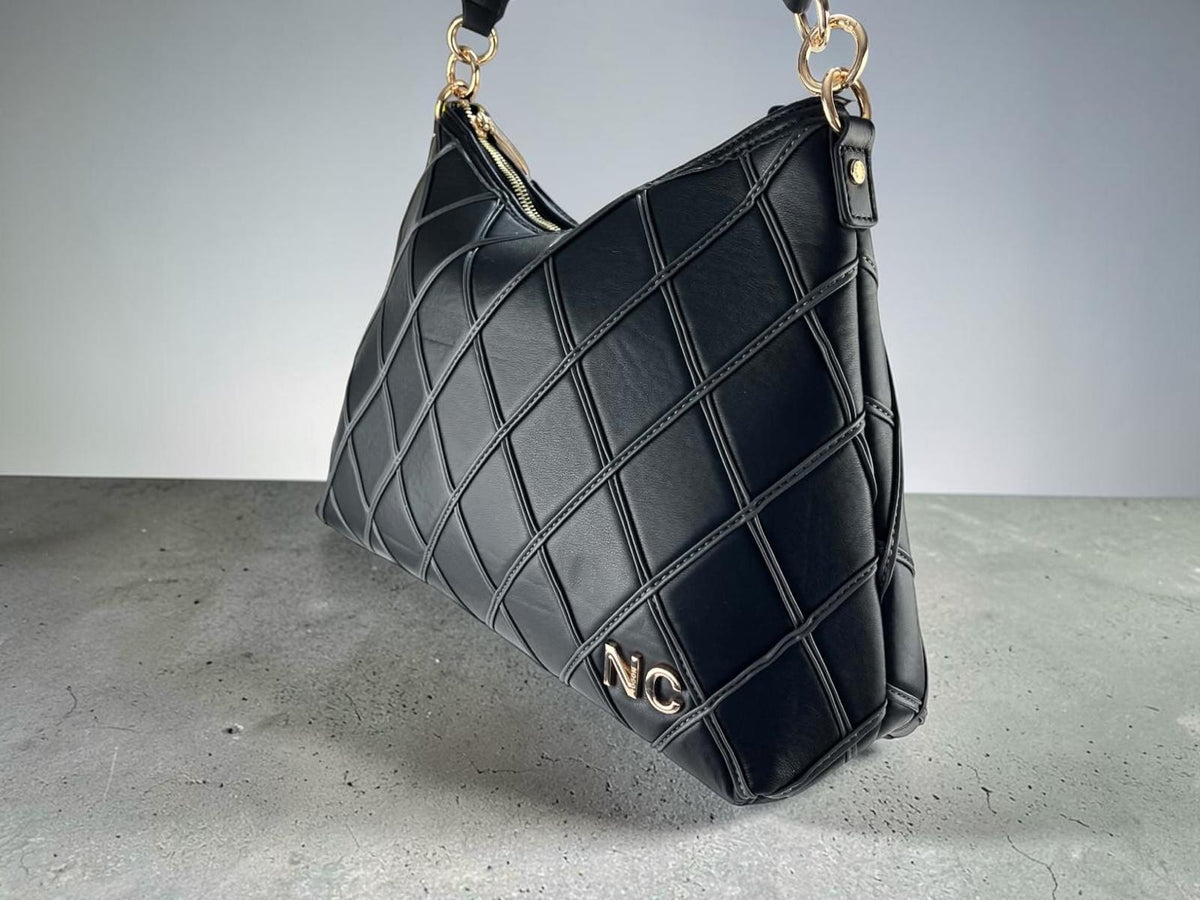 Bolso hobo Noco negro de piel vegana con rombos acolchados y herrajes dorados, vista frontal en ángulo.