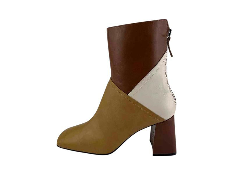Vista lateral de un botín en piel tricolor, camel,marrón y blanco, con tacón en bloque y cremallera por la parte trasera.
