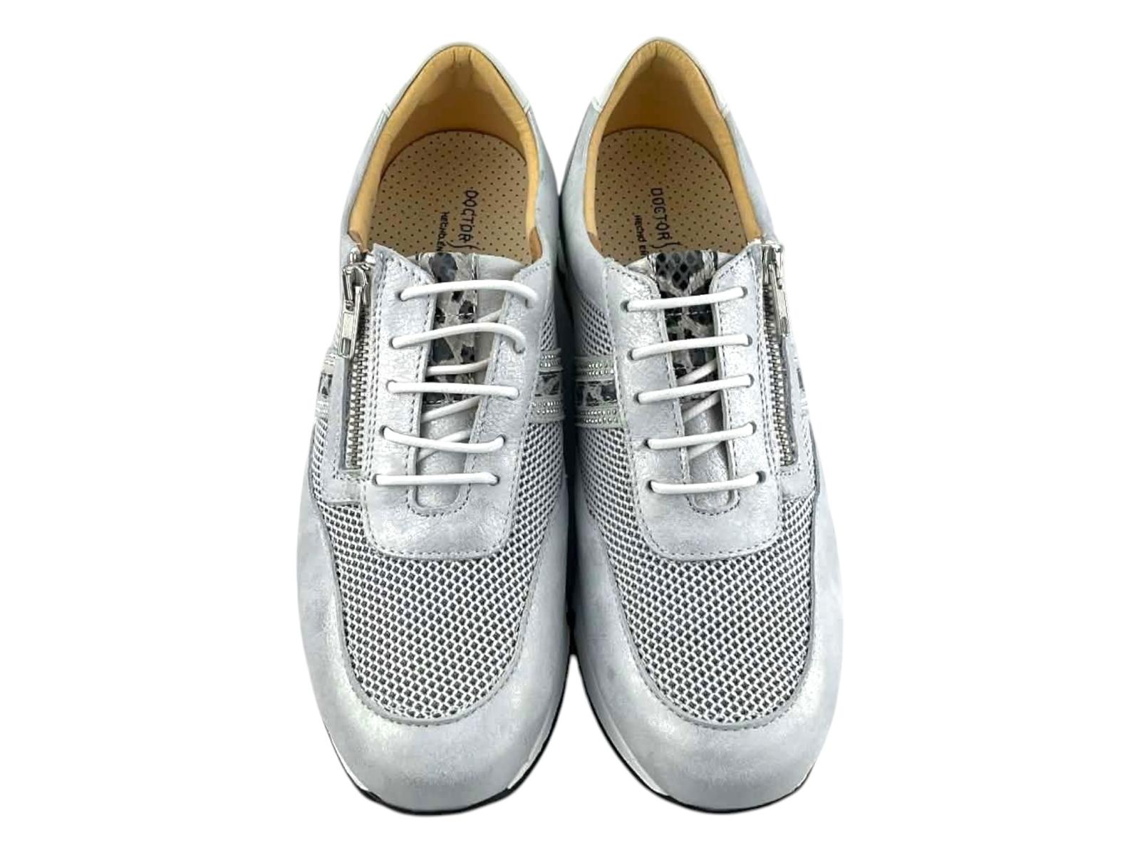 Plano frontal de de la cremallera funcional y los cordones elásticos en sneakers de lujo casual color plata transpirable.