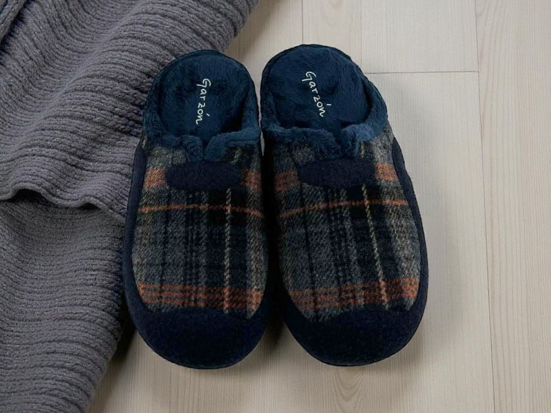 Pantuflas de la marca española Garzón para hombre, con cuadros en tonos azules y suela de goma antideslizante.