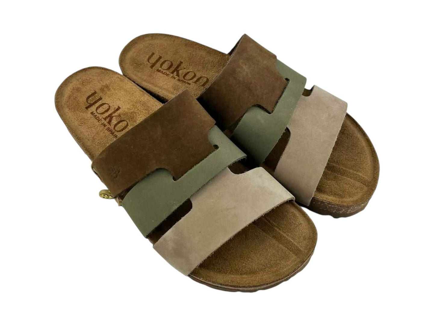 Sandalias de mujer en primer plano de la textura de las pieles marrón, verde y beige; el borde de corcho, resaltando el acabado artesanal 'Made in Spain' y la comodidad bio.