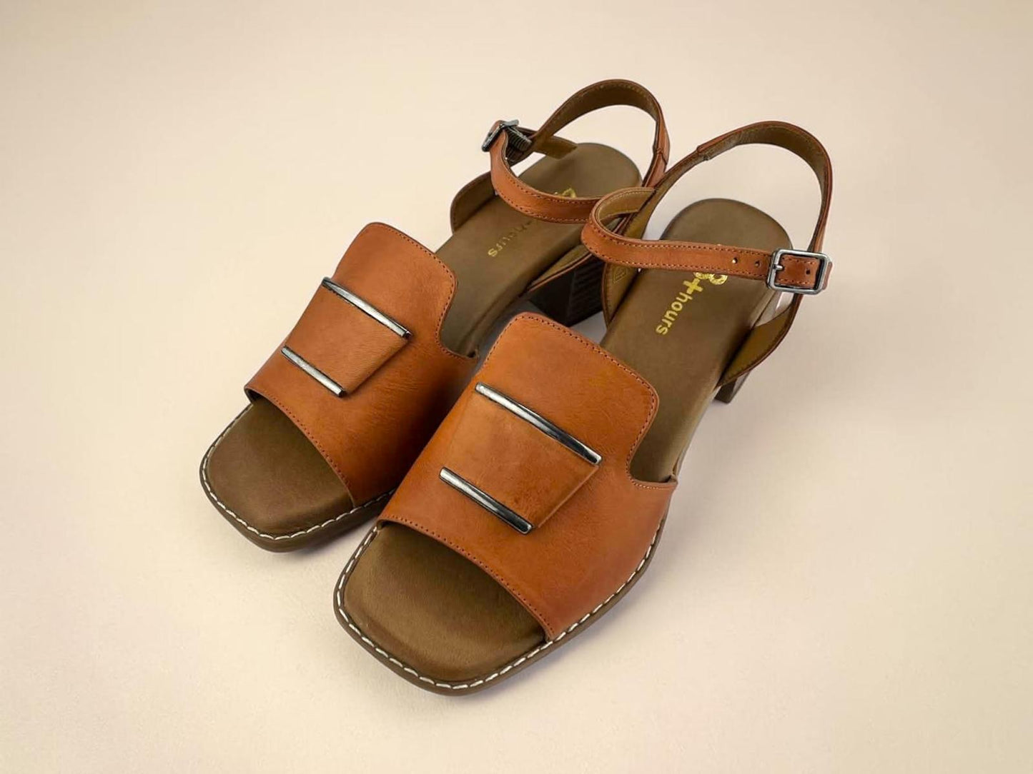 Sandalia 48Hours en piel camel con tacón bloque, apliques metálicos y cierre de hebilla. Diseño ergonómico de puntera cuadrada para un confort duradero y elegante.