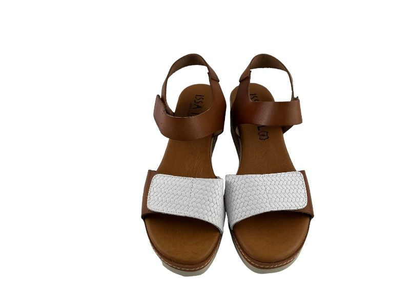 Sandalias de mujer en piel, con empeine en una tira ancha en color cuero y blanco. Vista frontal sobre fondo blanco.