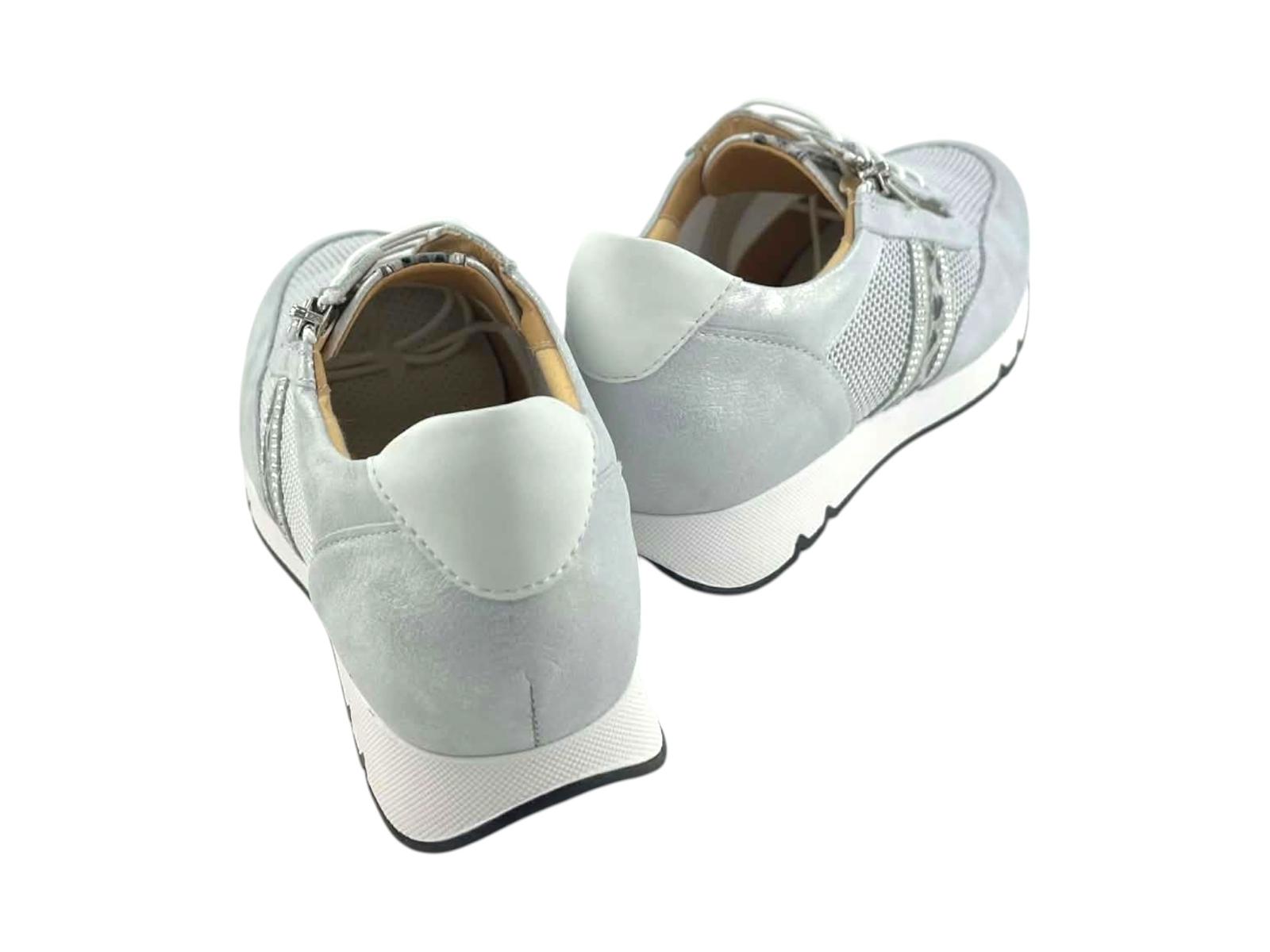 Vista posterior de sneakers confort mujer en tono plata y blanco, resaltando el talón acolchado y la suela con cuña ergonómica.