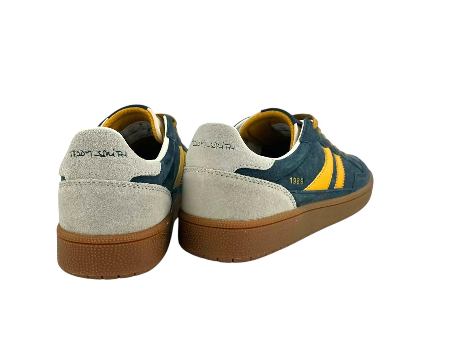 Vista por la parte de atrás de unos sneakers retro running 1989, con detalles de la marca en el talón y cuidada silueta en color caramelo. 