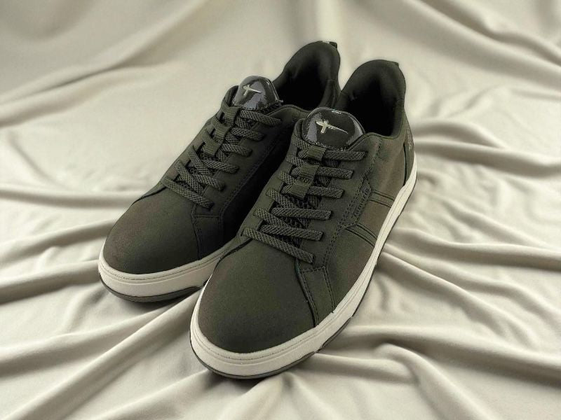 Zapatillas de moda verde militar de la marca Tamaris, con cordones, suela blanca y logo en el lateral y lengüeta sobre fondo de tela blanca.
