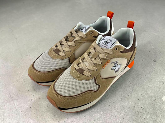 Perspectiva lateral de las sneakers premium de hombre en color beige destacando el acabado de la malla transpirable y su silueta sport.